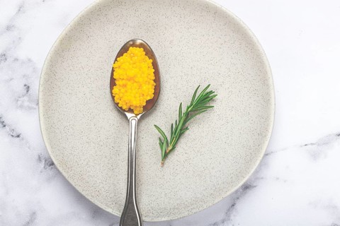 Yuzu caviar is pearly, on a spoon, top view, light background, no people.