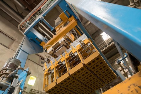 Brickyard. Bottom view of production machine with bricks
