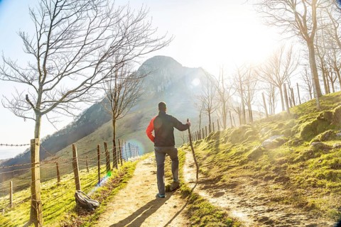 A man climbing Mount Ernio or Hernio in Gipuzkoa at sunset, Basque Country