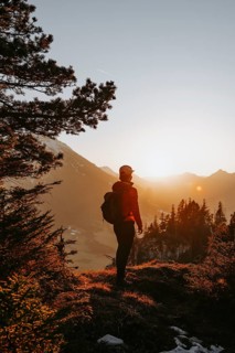 Hiker in the Allgäu at sunset in spring on the Zirmgrat near Pronten in the Allgäu