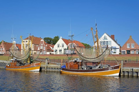 Crab cutter in the harbour in front of historic buildings, blue sky, Greetsiel, North Sea, Lower