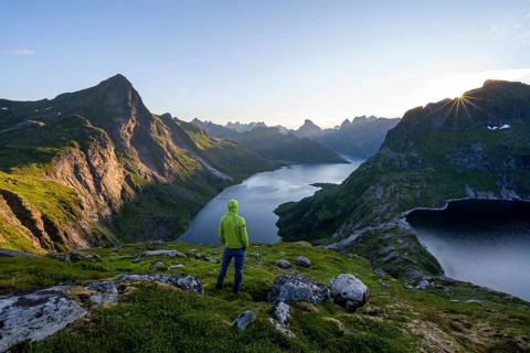 Mountaineer looking over mountain landscape with pointed mountain peaks and fjord Forsfjorden with