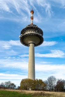 The telecommunications tower on the Köterberg rises into a blue sky with scattered clouds,