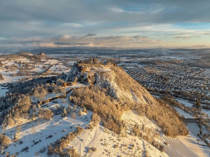 Aerial view of the snow-covered Hegau volcano Hohentwiel with Germany's largest castle ruins on a