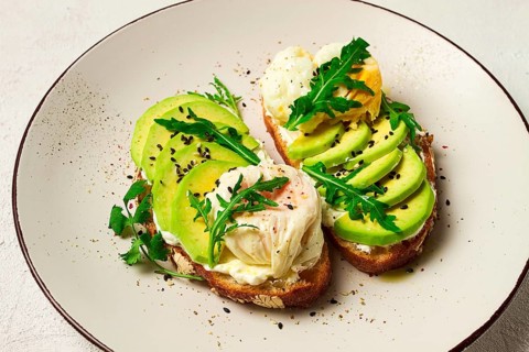 Sandwich with cream cheese, sliced avocado and boiled egg, arugula, on grainy bread, homemade,