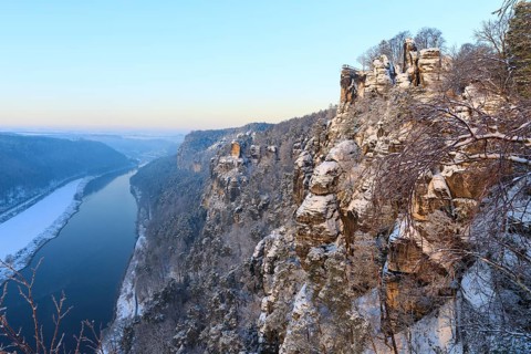 Kanapee viewpoint at the Bastei into the snow-covered Elbe valley with sandstone cliffs such as the