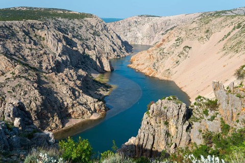 A river flows through a deep, rocky gorge with steep cliffs and clear watercourses, Pariževacka