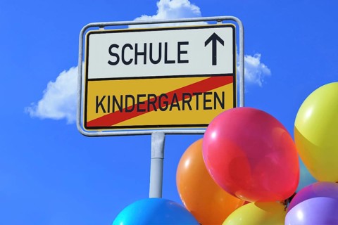 (Photomontage) Town exit sign with the lettering KINDERGARTEN/SCHULE