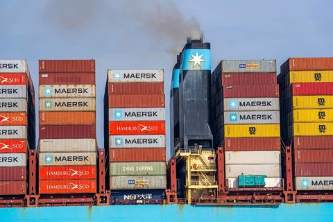 Container freighter Madison Maersk smoking chimneys of the ship's diesel engines, Maasvlakte 2,