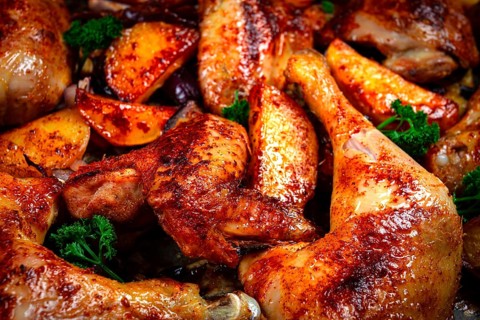 Roast chicken legs with potatoes and onions in the oven, homemade. No people.
