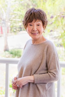 Happy senior chinese woman poses for her portrait outdoors