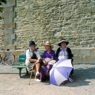 Women on a bench in front of the city wall of St.Malo, Brittany, France
