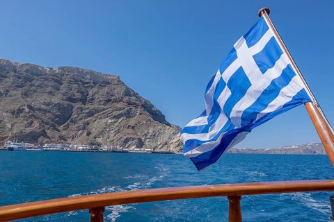 Greek flag waving in the wind on a boat, Greece