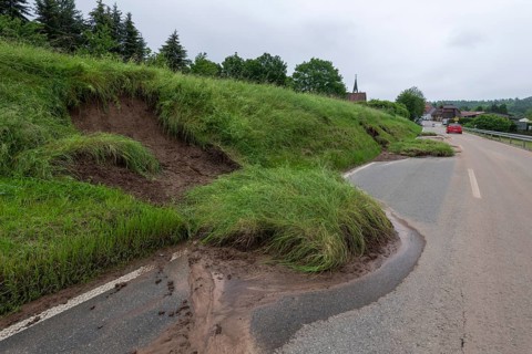 Symbolic image of climate change, slippery slope on a country road after heavy rainfall, near