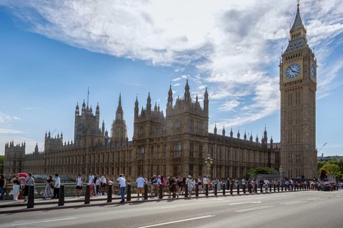 View of Big Ben and the Palace of Westminster with many tourists in the foreground under a partly