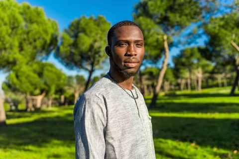 Portrait of a young african man from senegal wearing traditional clothing in a park, representing