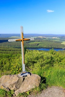 Small summit cross on the Bärenstein with a view of the Cranzahl dam, Erzgebirge, Saxony, Germany