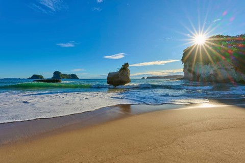 Sunbeams breaking over a rocky beach, Cathedral Cove, Coromandel, Canterbury, North Island, New