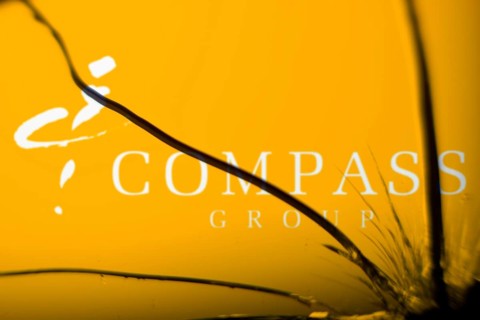 Compass Group logo is visible on the broken glass