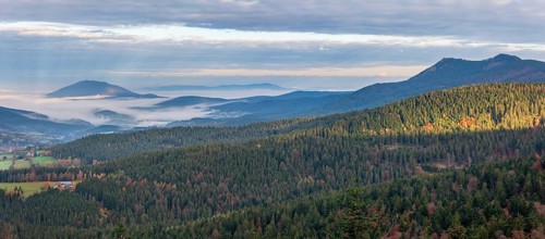 View from the Hindenburgkanzel over endless forests in autumn with valley fog, on the right the