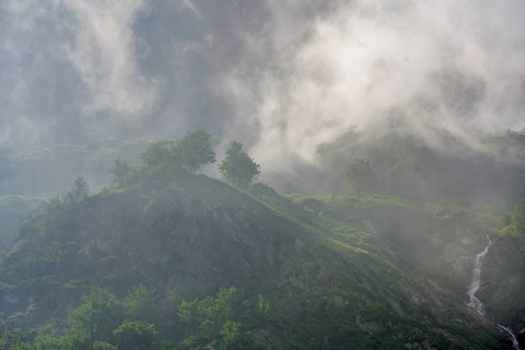 Clouds move over the mountains after a rain shower at Lago della Rovina, Entracque, province of