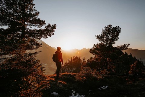 Hiker in the Allgäu at sunset in spring on the Zirmgrat near Pronten in the Allgäu