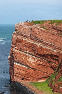 Red coloured sandstone, steep cliff coast of the offshore island of Heligoland, home of the