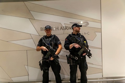 Two armed police officers on duty inside South Terminal, London Gatwick airport, England, UK