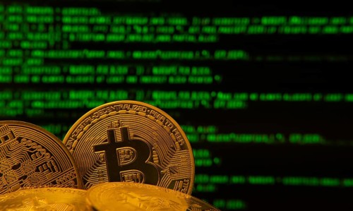 Golden bitcoins in front of green digital code, symbolizing cryptocurrency and technology