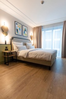 A bright and modern hotel room with a large bed and paintings on the wall, Berlin, Germany