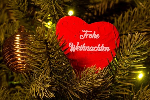 Christmas greetings: Heart with the inscription FROHE WEIHNACHTEN on a Christmas tree