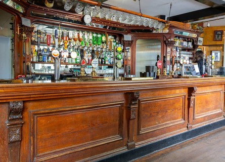 Traditional wooden bar counter with beer pumps inside Nova Scotia Hotel public house bar, Bristol,