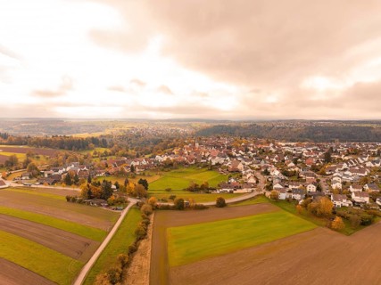 View of a town in an autumnal landscape with clouds in the sky, Tiefenbronn, Germany