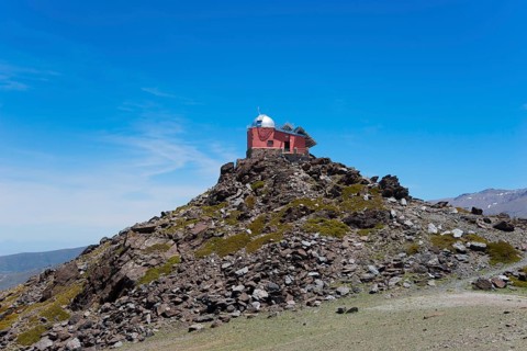 Red observatory building on a rocky hill under a blue sky, Obversatorium, Mohon del Trigo