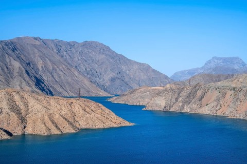 Blue Toktogul reservoir between dry mountain landscape, Jalalabad region, Kyrgyzstan