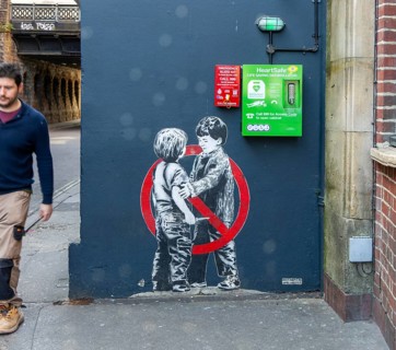 Mural street art two young boys one with knife Anti knife piece 2020 by JPS artist Jamie Scanlon,