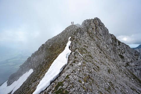 Two mountaineers on the rocky ridge, ascent to the Ackerlspitze, clouds moving around the