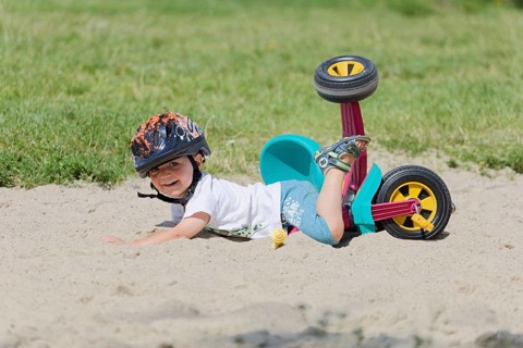 A boy in a helmet fell on his bicycle. Pobierowo, Poland
