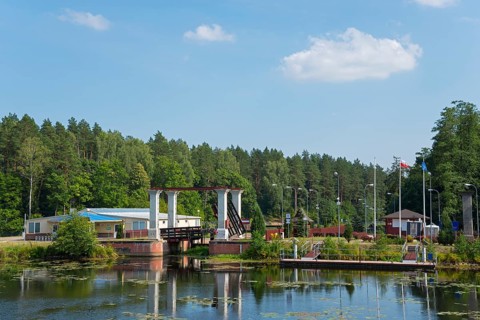 Lock with bridge and neighbouring building in forest landscape in sunshine, Sluza Kurzyniec, Sluza,