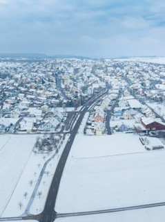 Aerial view of a small snow-covered village surrounded by fields, Deckenpfronn, Böblingen district,