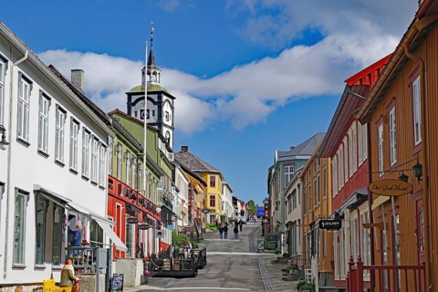 City street with colourful buildings, a striking church and light clouds in the blue sky, Unesco