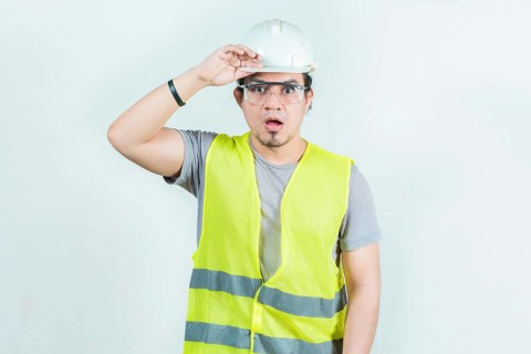 Surprised engineer looking into the distance isolated. Amazed latin engineer looking into the