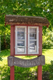 Small, wooden building with windows and an old sign in the countryside, Rügen, Hiddensee