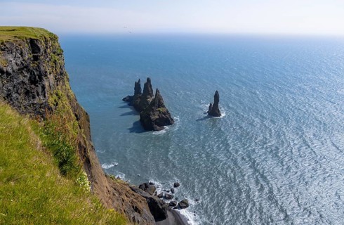 Cliff, rock Reynisdrangar in the water, on Reynisfjara beach, Vik, South Iceland, Iceland