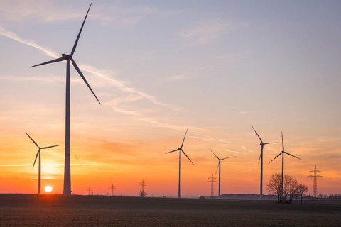 Wind turbines in front of a colourful sunset on the horizon in an open landscape, near Ulm, Swabian