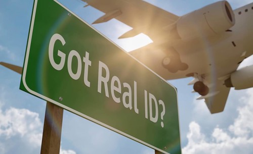 Got real ID? green road sign with low flying airplane just above with landing gear down