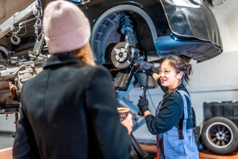 Skilled mechanic discussing vehicle maintenance with a customer, highlighting professionalism and