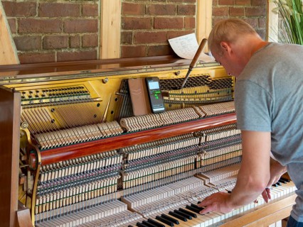 Piano maker repairing piano, piano tuner working on open old piano, Germany