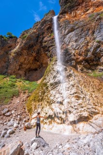 Female hiker enjoying majestic rinka waterfall in picturesque logarska dolina valley, savinja alps,