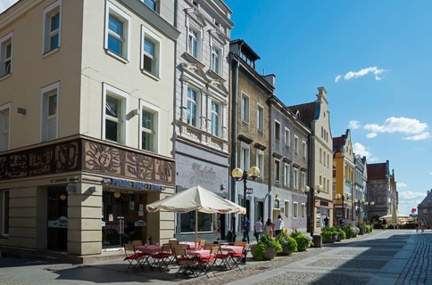 Charming old buildings along a quiet, sunny pedestrianised street with cafés, Old Town, Olsztyn,